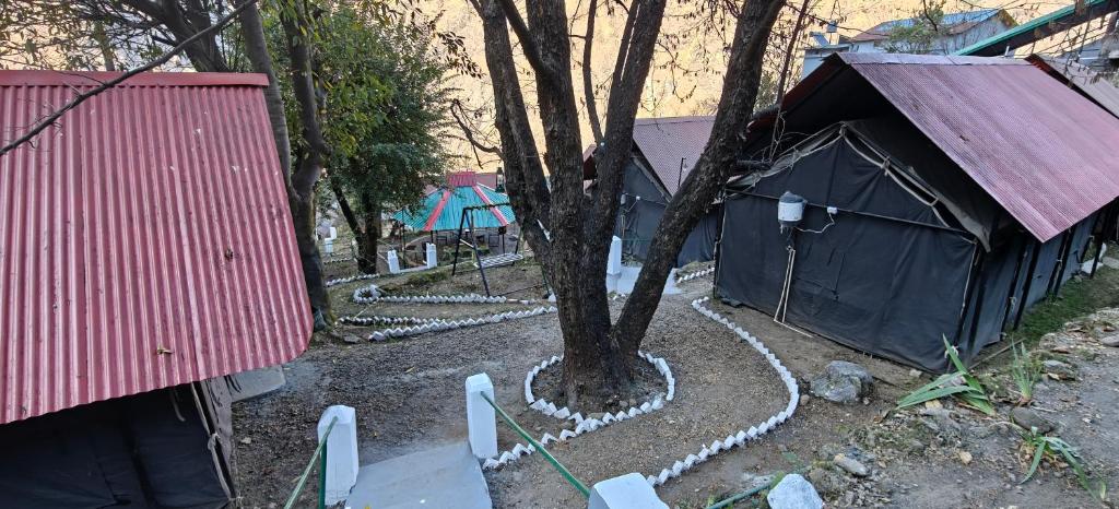 a tree in a yard next to a building at Zero Degree Camps in Joshīmath