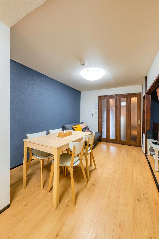 a dining room with a table and chairs and a couch at YAGARA TERRACE HOUSE OSAKA Room B in Osaka