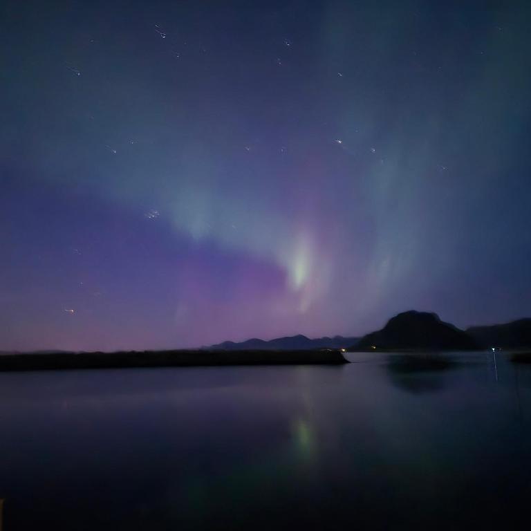 a view of the aurora over a lake at night at Lofoten Sunset & Ocean VIew in Valle