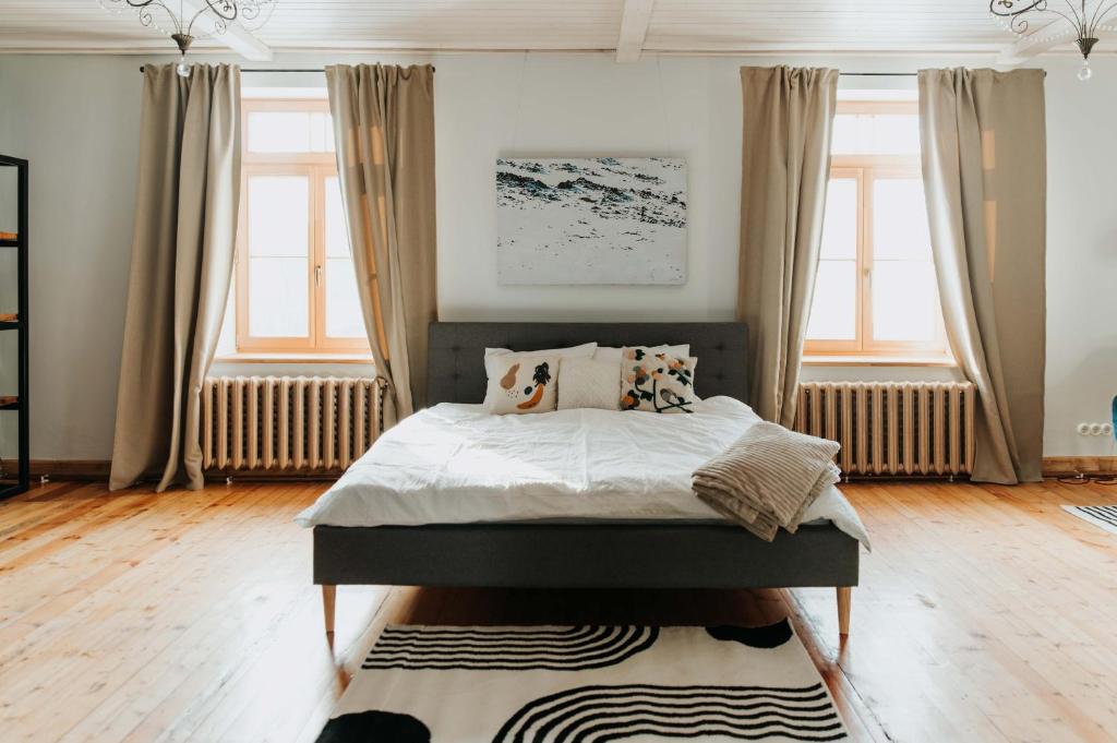 a bedroom with a bed and two windows at STRIĶU15 - Plašs studio dzīvoklis in Saldus