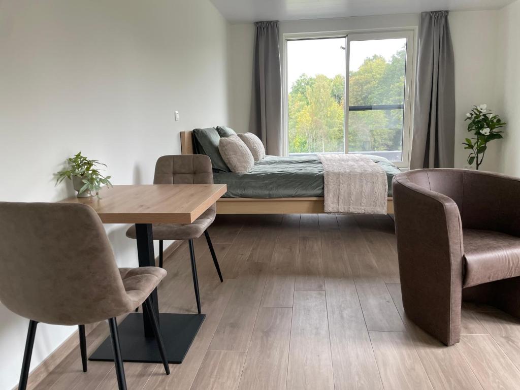 a bedroom with a bed and a table and chairs at Le Grand Pont in Vielsalm