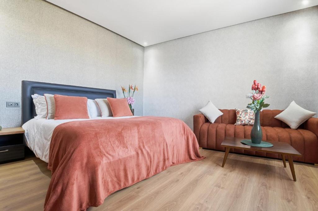 a bedroom with a bed and a couch at OXANA By Atlasia in Agadir