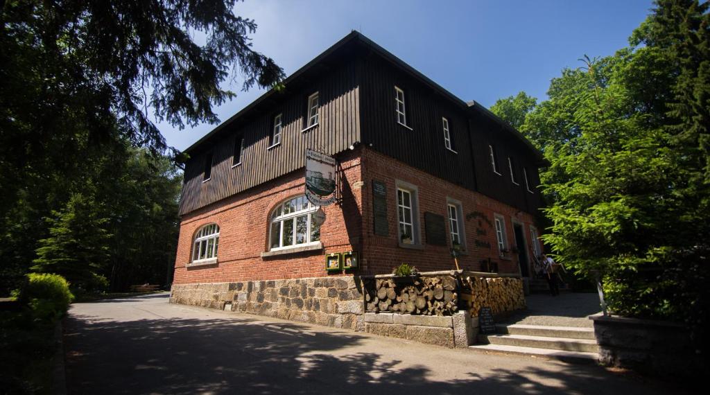 ein rotes Backsteingebäude mit schwarzem Dach in der Unterkunft Naturresort Bieleboh in Beiersdorf