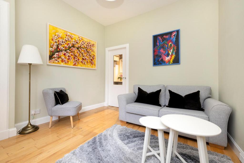 a living room with a couch and a table and a chair at Cosy town centre cottage in Peebles