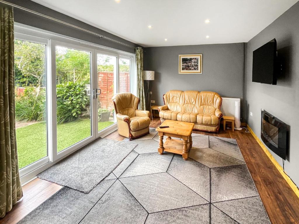 a living room with a couch and two chairs at Orcadians in Sellindge