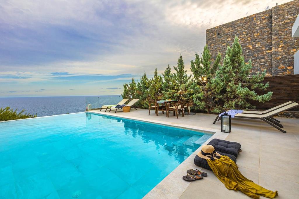 a swimming pool with a view of the ocean at Villa Harmonie in Achlia
