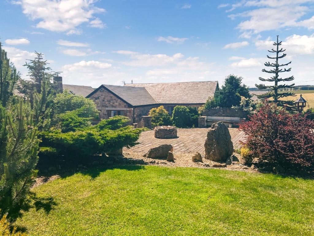 a garden with rocks and a house in the background at Keppel Gate in Heriot