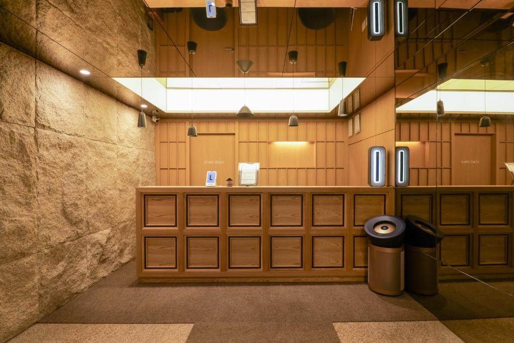 a large room with wooden doors and a trash can at 잠실 라운지 호텔 in Seoul