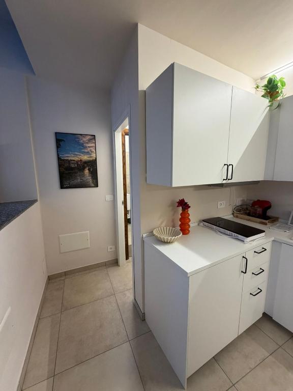 a kitchen with white cabinets and a tile floor at Casa Bago in Ivrea