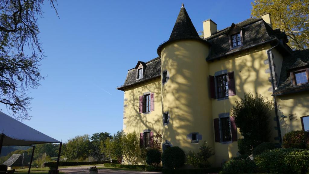 a large white building with a black roof at Resort Golf Château de Salles in Vezac