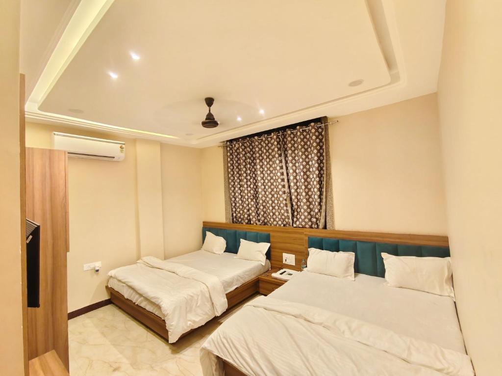 a hotel room with two beds and a window at Hotel Sanskar Palace in Godarpura