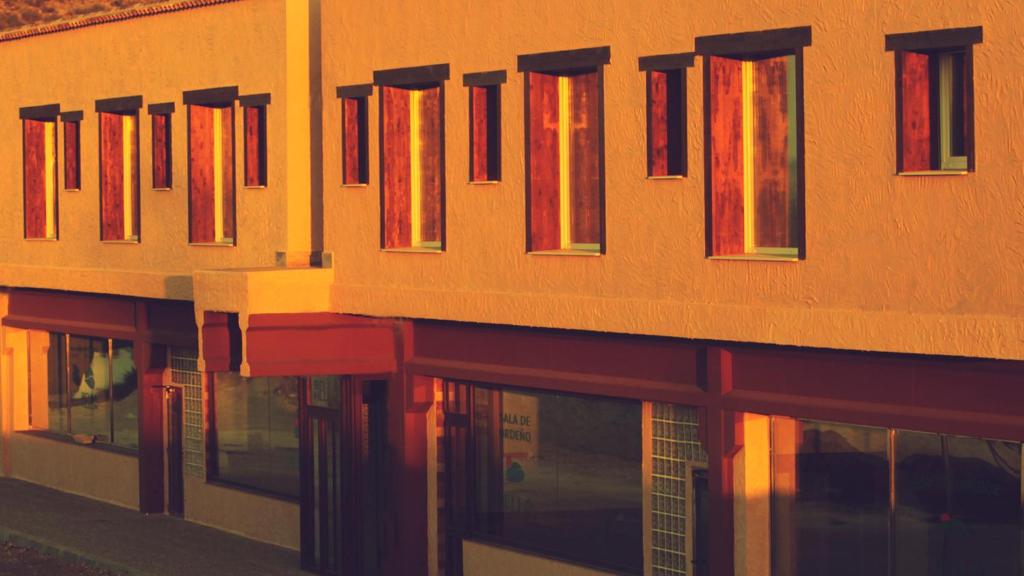 un edificio anaranjado con ventanas rojas en el lateral. en Hotel Bella Hellín, en Hellín