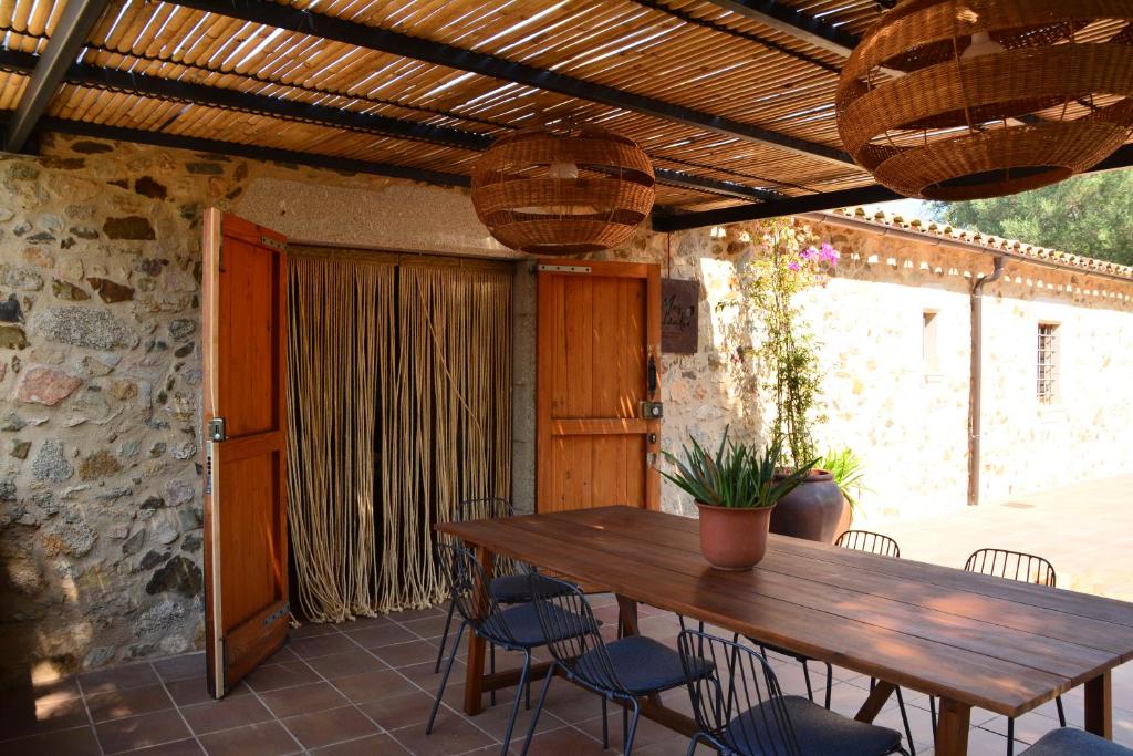 a wooden table and chairs on a patio at Mas Salvador Rural Experience in Llagostera