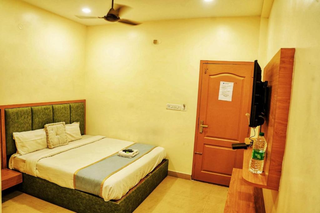 a small bedroom with a bed and a tv at Qubehotelinn in Cochin