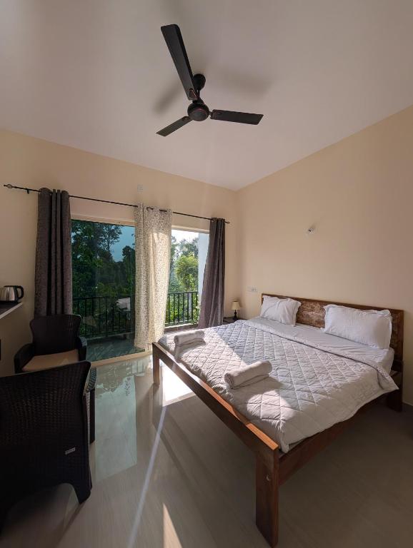 a bedroom with a bed and a ceiling fan at Bougain Villa in Madikeri