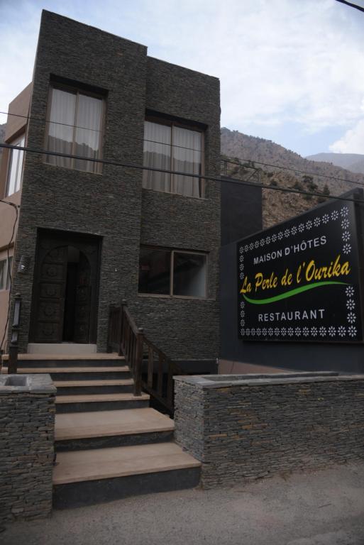 a brick building with a sign in front of it at La Perle Ourika Valley Guest House in Ourika
