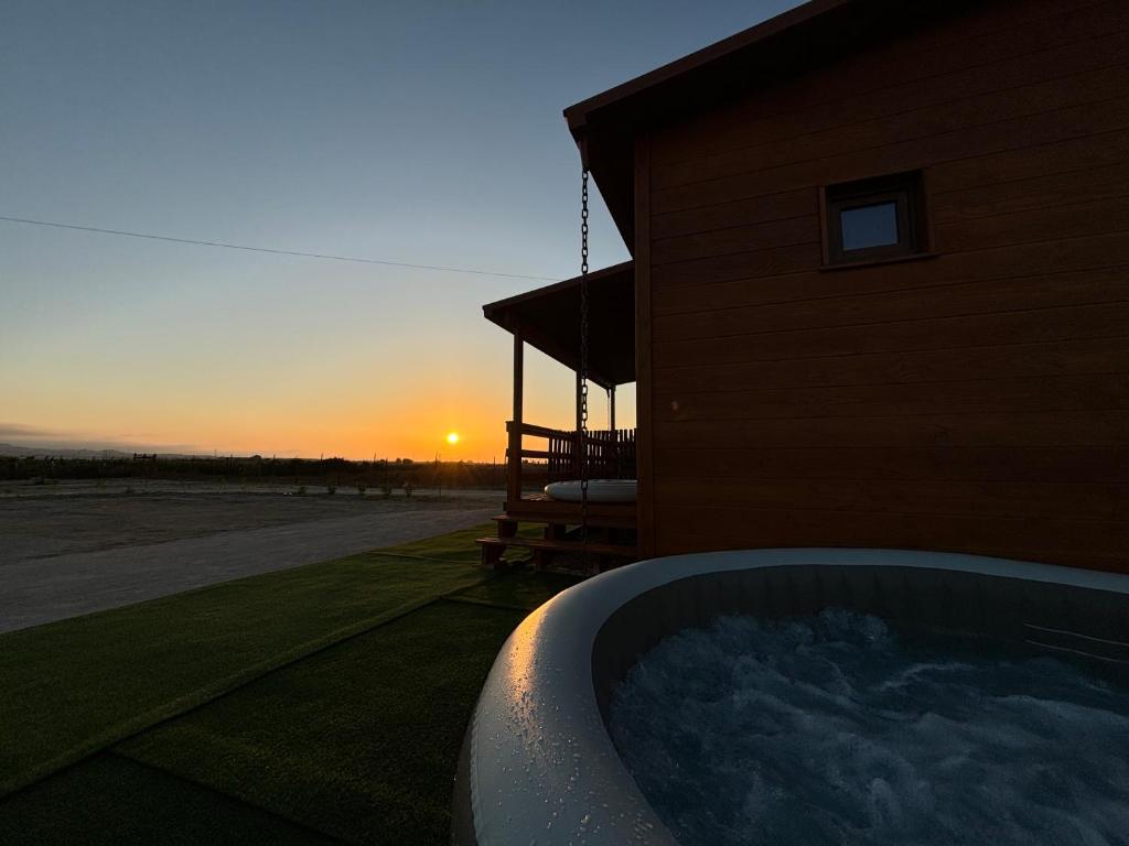a hot tub in front of a building with the sunset at Grape Escape, By Home Match in Palmela