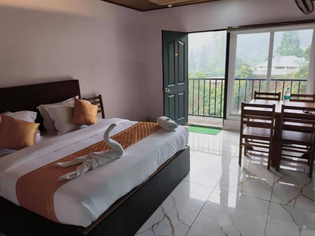 a bedroom with a large bed and a balcony at Hill view cottage cj in Devikolam