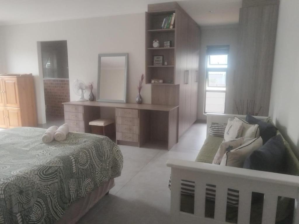 a bedroom with a bed and a desk and a mirror at Lavender Suite in Gansbaai