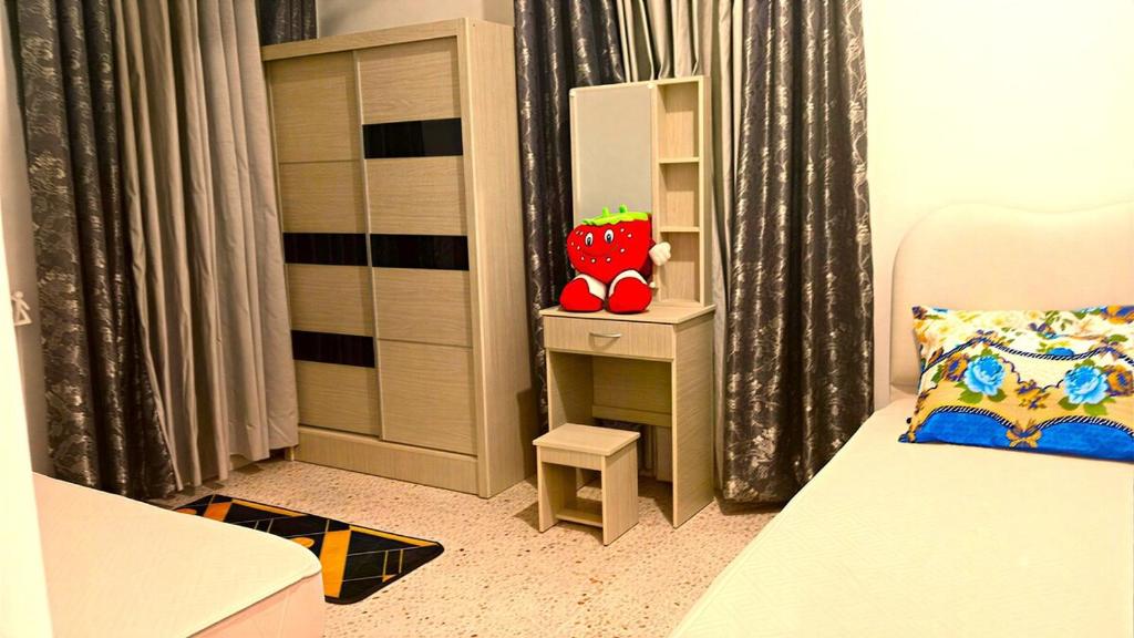a small bedroom with a bed and a shelf and a table at A K Homestay in Sungai Petani