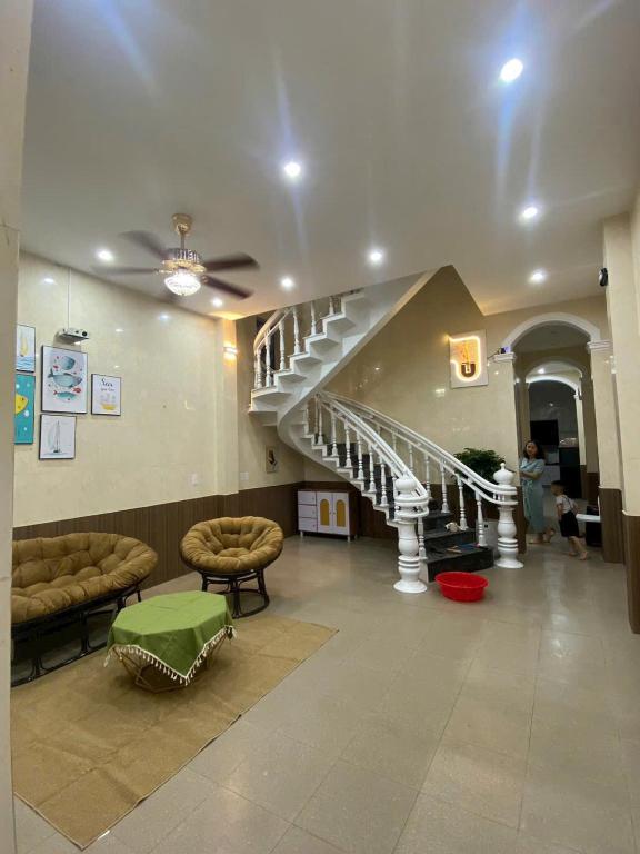a lobby with a staircase in a building with a person at Homestay Lumina in Dong Hoi