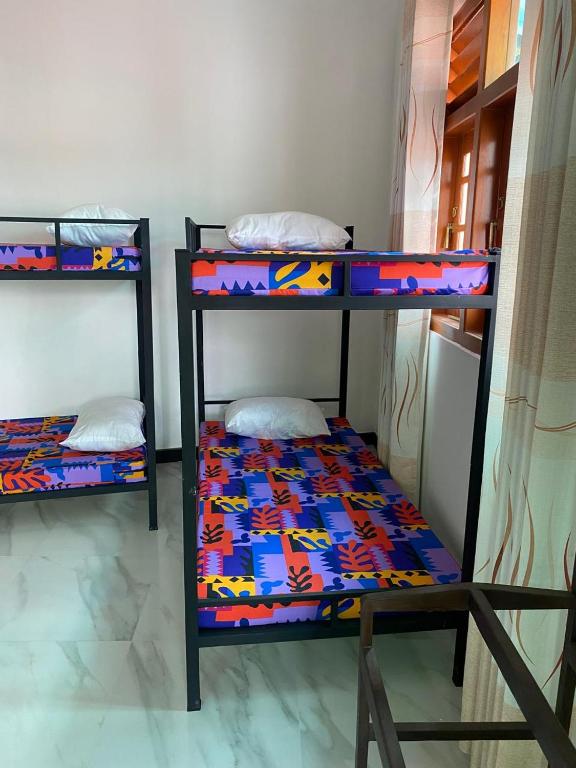 a room with two bunk beds in a room at Chandani Hostel in Galle