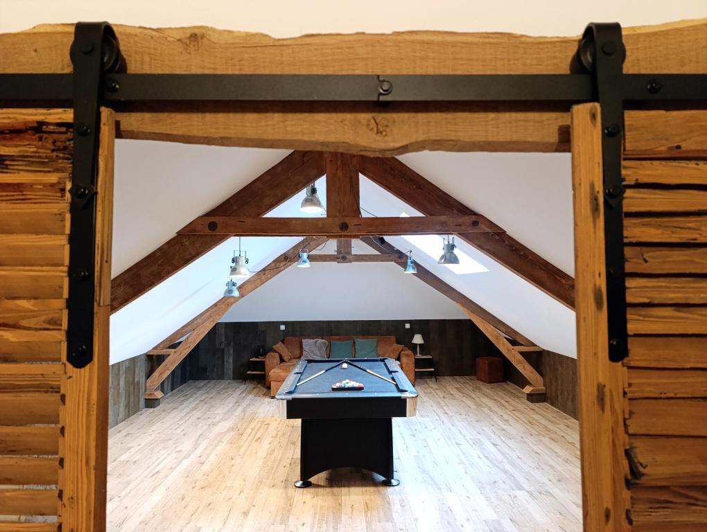 a loft with a table in the middle of a room at Le repaire Ardennais in Rossart
