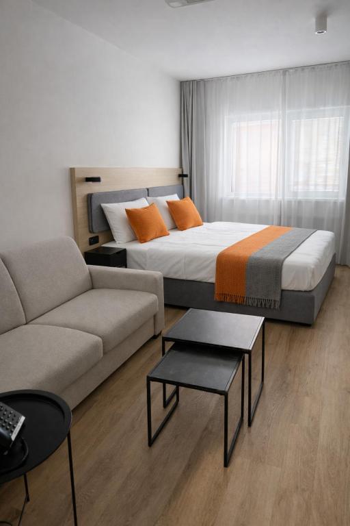 a hotel room with a bed and a couch at Hotel Kapitol in Most