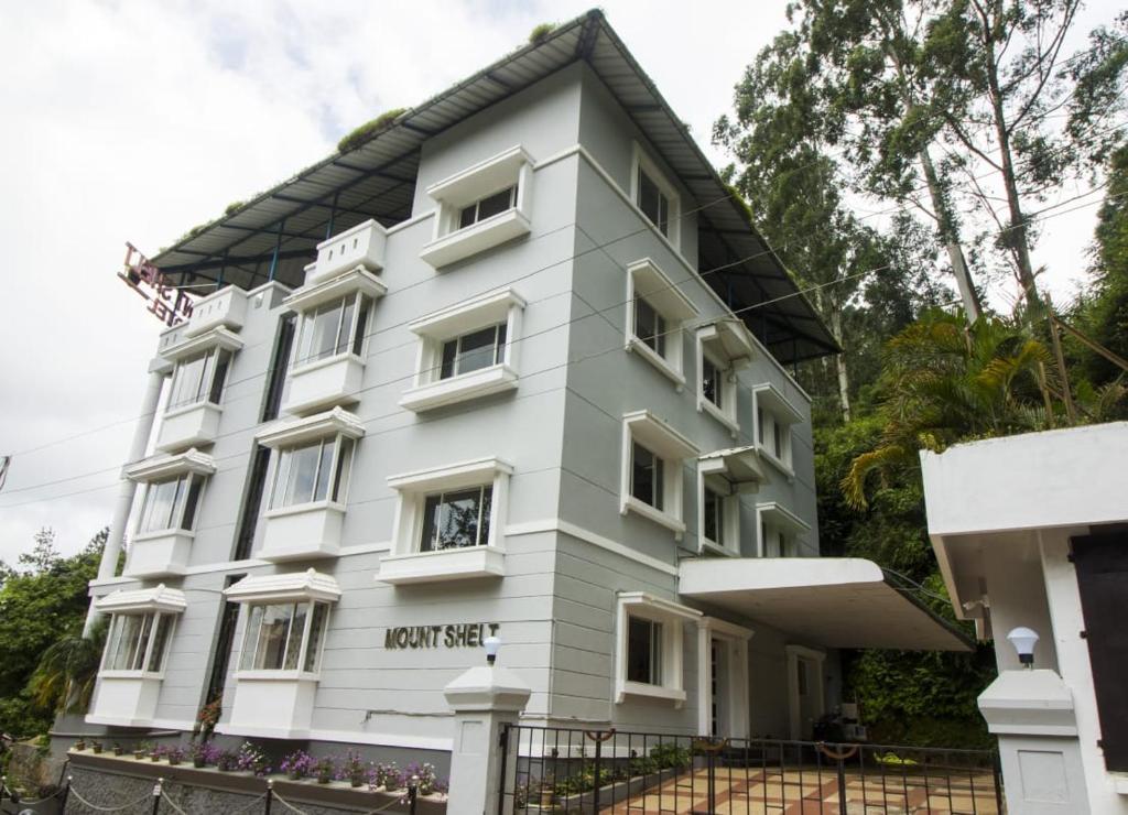a white building with a black roof at Mounts shelts in Munnar