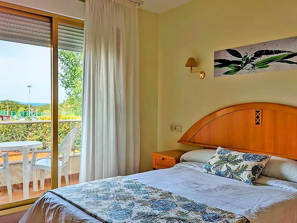 a bedroom with a bed and a balcony with a table at Hotel Mar del Norte 3000 in O Grove