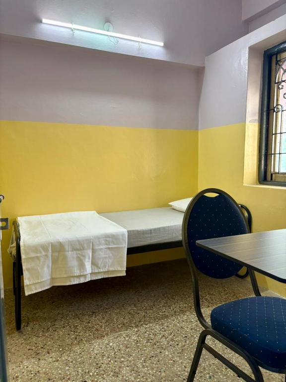 a room with a bed and a table and chairs at Urban Mansion Triplicane in Chennai
