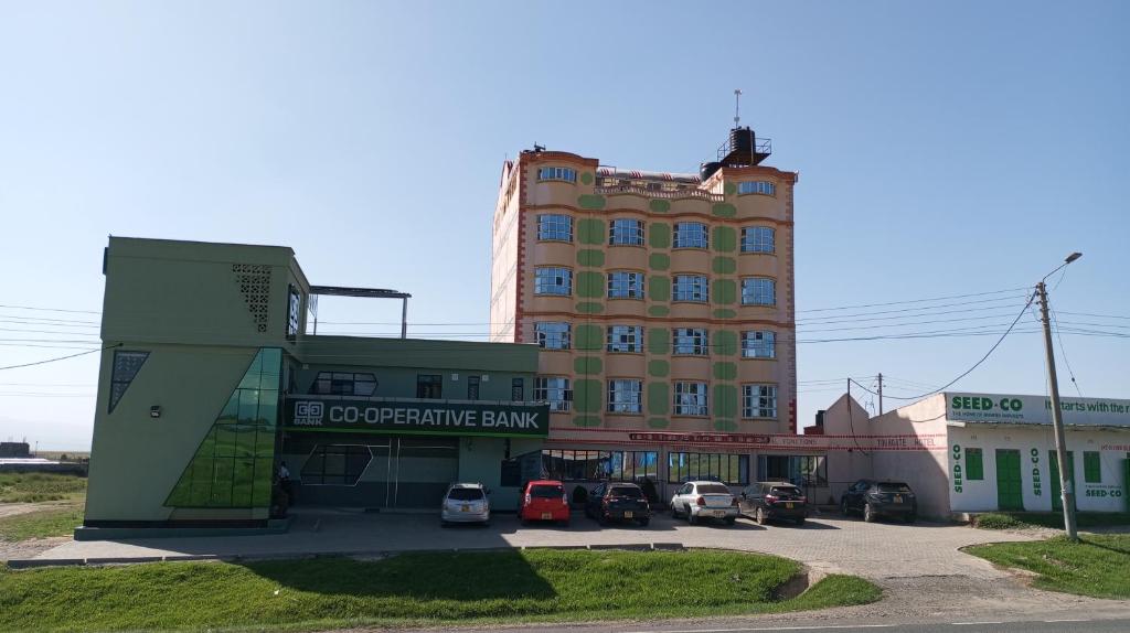 a large building with cars parked in a parking lot at Tour Gate Hotel in Naro Moru