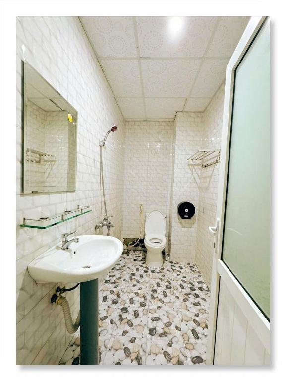 a bathroom with a sink and a toilet at LUNA House in Phú Vang