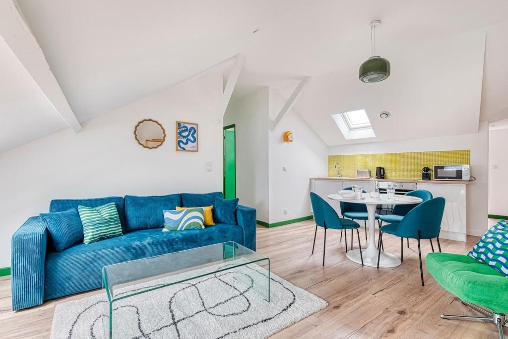 un salon avec un canapé bleu et une table dans l'établissement Le Logis - 6 prs - Hyper, à Saumur