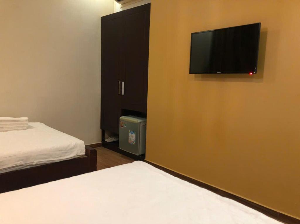 a room with two beds and a flat screen tv on a wall at namhan in Phú Quốc