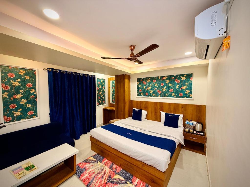 a bedroom with a bed with blue pillows at Hotel Shree Darshan - Near Mahakal Mandir Ujjain in Ujjain