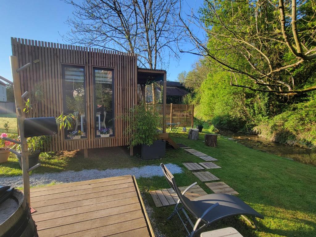 a tiny house in a garden with a wooden deck at La Casa du Vau - Tiny House in Bussy-le-Grand