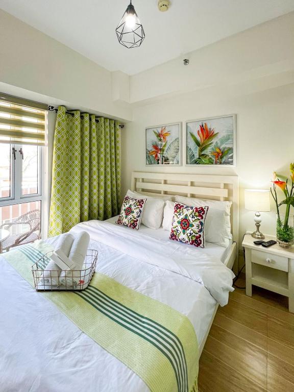 a bedroom with two beds and a window at Little Treasure Tagaytay-Flora in Tagaytay
