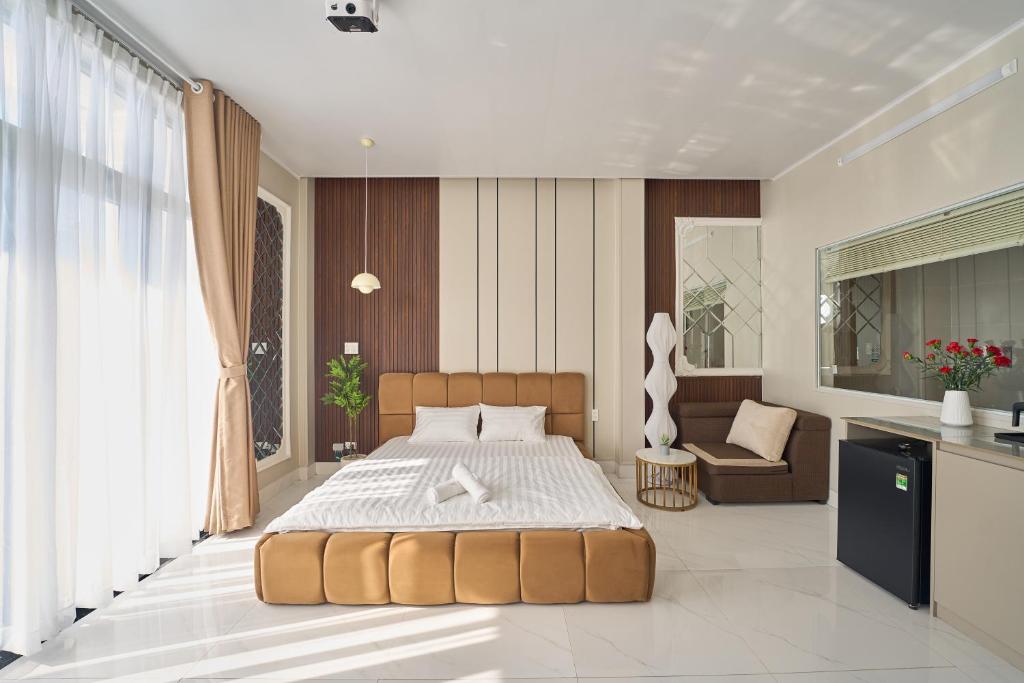 a bedroom with a large bed and a chair in it at Minh Nhat Villa - 3S Villa in Cồn Giả Viên