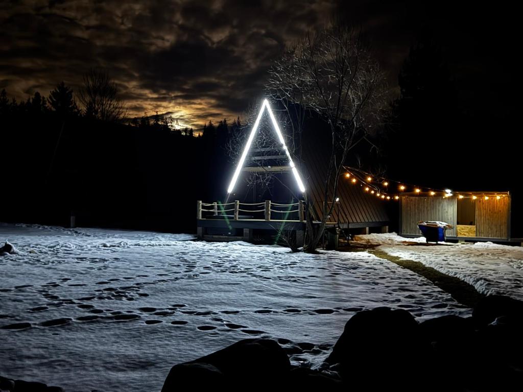 a lit up pyramid in the snow at night at 3A-CHALET-LIBaN in Liban