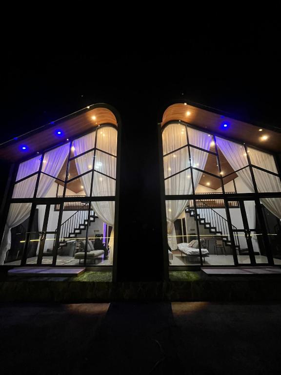 a view of a building with windows at night at The Siterus Villa Dieng in Wonosobo