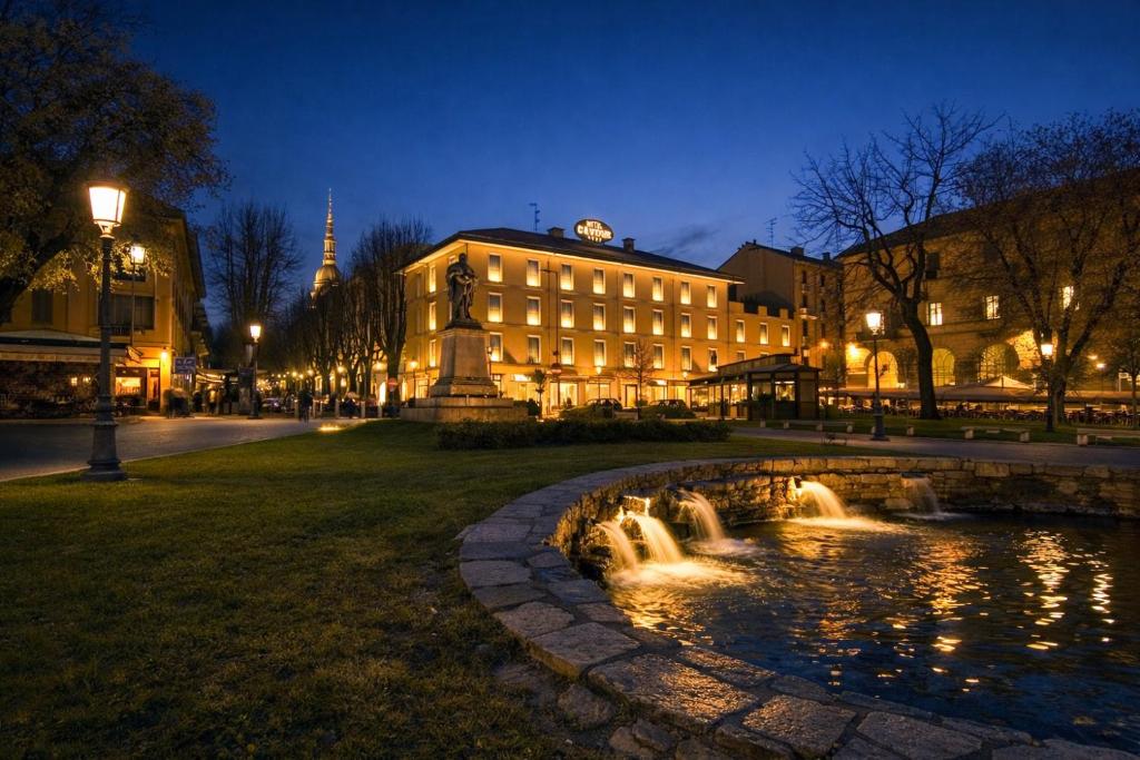 a fountain in front of a building at night at LVG Hotel Collection - Cavour in Novara