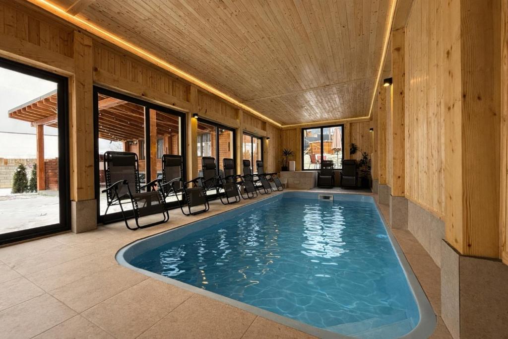 a large swimming pool in a house with windows at Casa Ambra in Sadova