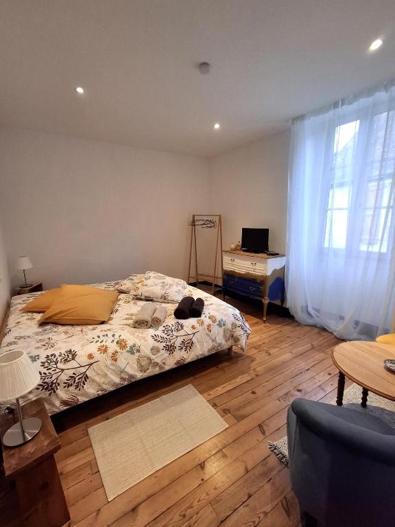 a bedroom with a bed and a table and a window at La maison de Lau in Salies-de-Béarn