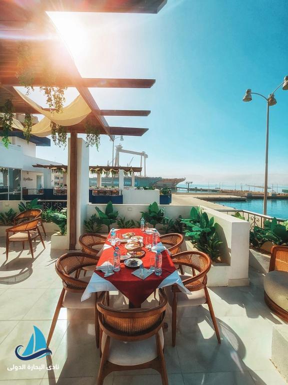 a table and chairs on a patio with a view of the ocean at نادي البحارة الدولي - International Seamans Club in Suez