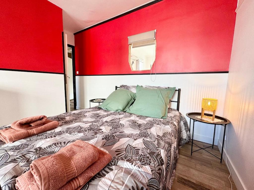 a red and white bedroom with a bed and a mirror at Chez Mamie Cloclo in Calais