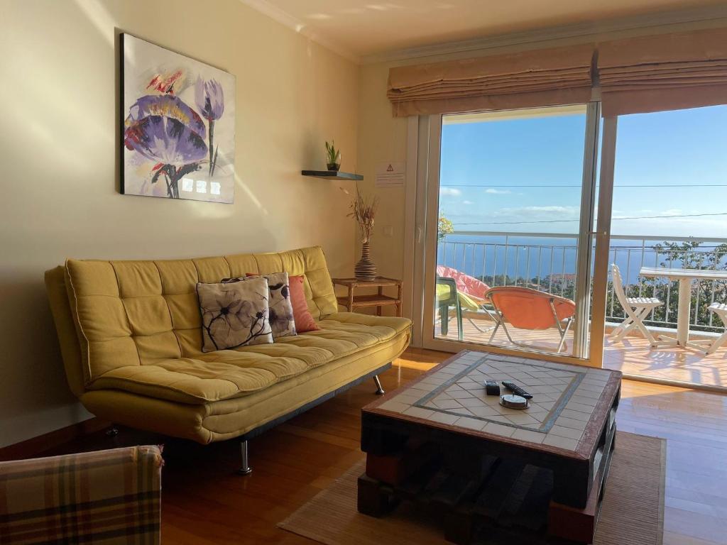 a living room with a couch and a view of the ocean at Apartamento Jade in Caniço