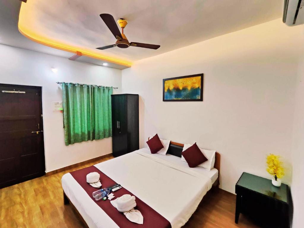 a bedroom with two beds and a ceiling fan at Samudrasneha Resort in Nagaon