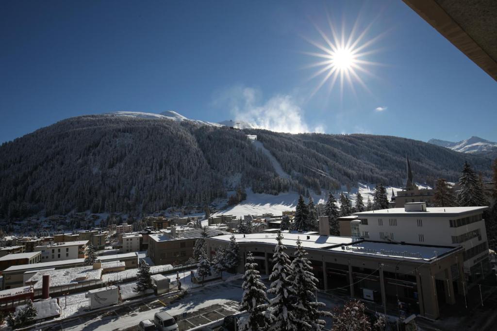 ダボスにあるApartment In Center Of Davosの空の日が降り注ぐ山の景色