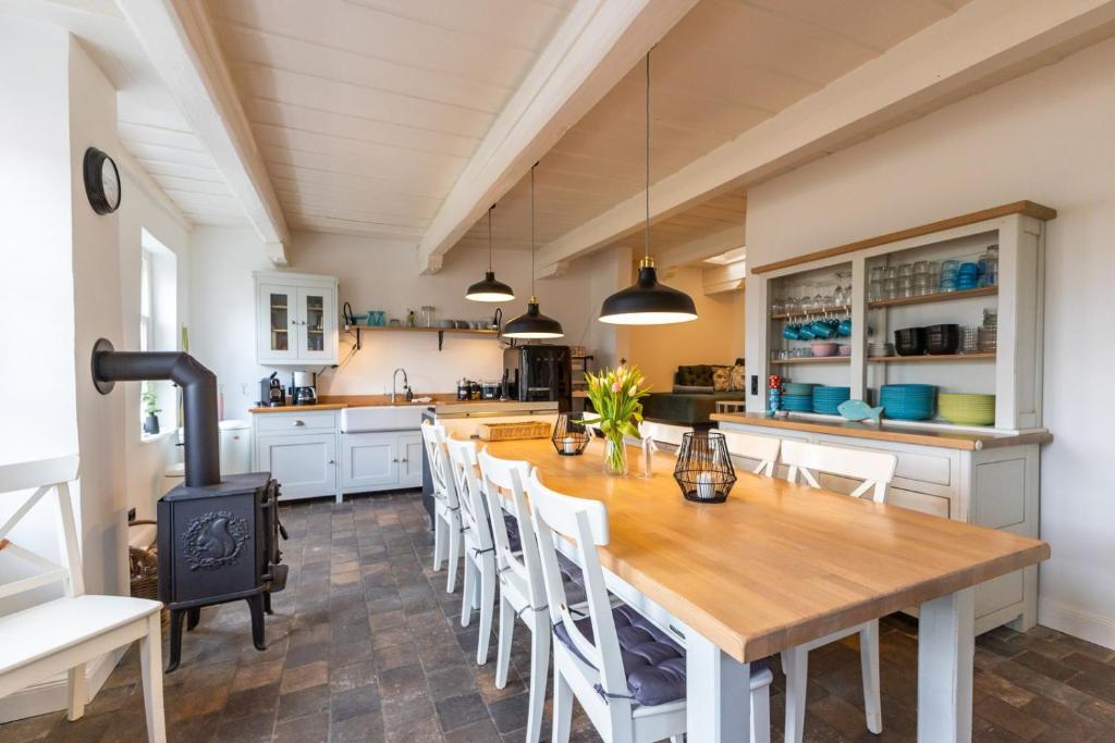 a large kitchen with a wooden table and chairs at K94 Fischerhaus in Greetsiel